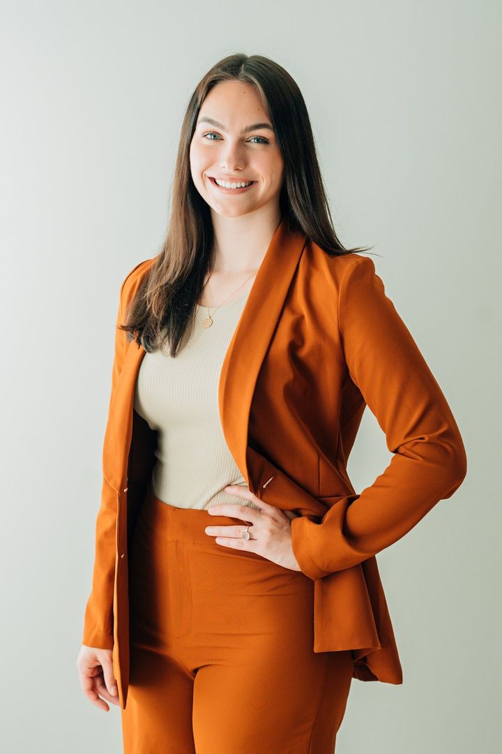 Sydney Mason, REALTOR®, in a burnt-orange suit